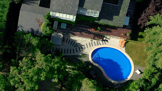 casa con piscina fotografiada con dron desde el aire